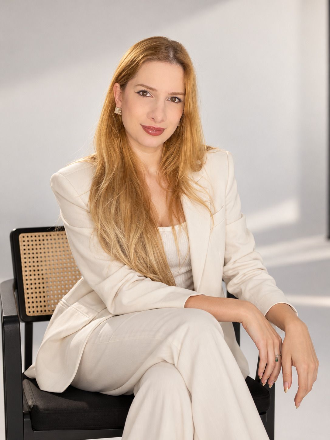 Karoline Trombim sentada em uma poltrona, sorrindo